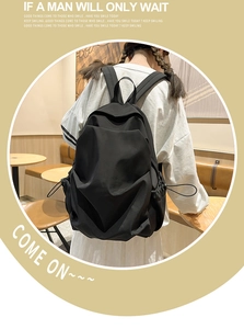 Side view of black pleated backpack featuring drawstring pocket and durable nylon texture