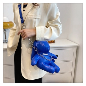Detail of royal blue bear crossbody bag in glossy PU leather with silver chain strap