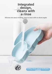 Waterproof silicone baby plate being rinsed under a faucet with water droplets