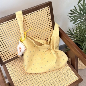 Detail of floral canvas tote bag on vintage chair with cute white duck plush accessory