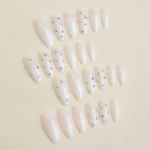 Almond-shaped milky white press-on nails with colorful rhinestones in a 24-piece set