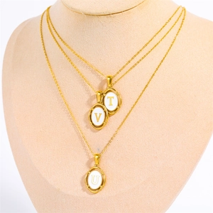 Close-up of triple layered gold necklaces with oval pendants featuring U, V, and T initials