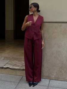 Detail shot of a wine red V-neck vest and matching high-waist wide-leg trousers