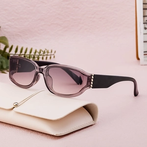 Fashionable square purple gradient sunglasses resting on an elegant cream leather case