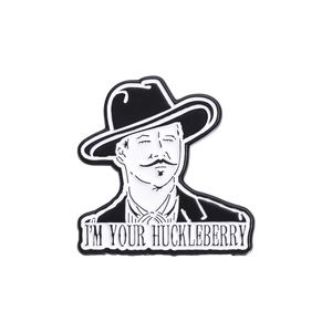 Cowboy hat character enamel pin with I'm Your Huckleberry text on white background