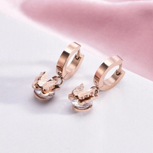 Elegant rose gold butterfly earrings with matte finish and crystal accents on a velvet cloth