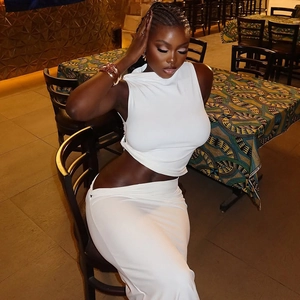 Chic white two-piece knit set featuring a halter top and high-waisted maxi skirt