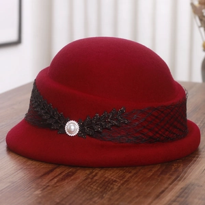 Détail d'un béret en laine bordeaux avec dentelle noire, perles et ornements strass