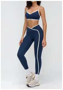Detail of high-waisted navy yoga leggings with V-cut waist and white side piping details