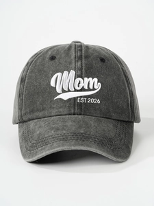 Close-up detail of Mom EST 2026 white embroidery on a washed grey cotton baseball cap