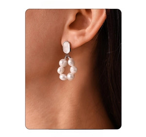 Close-up of elegant freshwater pearl drop earrings with silver geometric accents