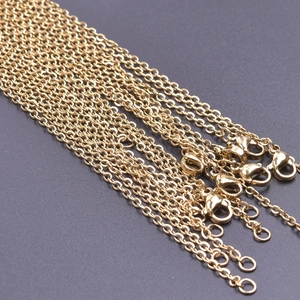 Detailed macro view of 18k gold-plated 2mm stainless steel cross chains with lobster clasps
