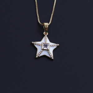 Detailed macro of a gold-plated starfish star pendant with white enamel and zircons