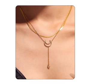 Close-up of double-layered gold star and moon necklace with zircon fringe on model