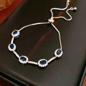 Detailansicht eines verstellbaren Silberarmbands mit fünf ovalen blauen Zirkonen und Boxkette
