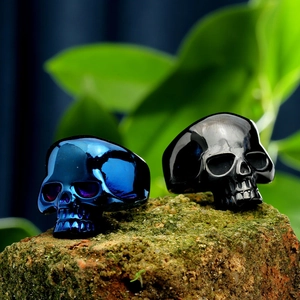Detailed macro view of punk skull rings in polished blue and black finishes on rustic bricks