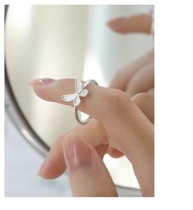 Close-up of elegant silver butterfly ring on model finger with detailed texture