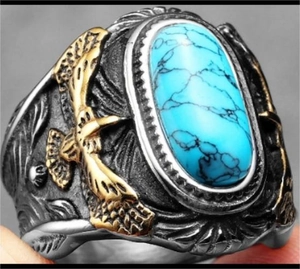 Macro shot of vintage silver ring with eagle relief and blue turquoise centerpiece