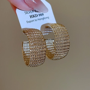 Detailed macro view of S925 silver C-shaped earrings with gold mesh woven texture