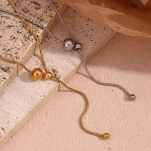 Detailed macro view of gold and silver Y-shaped snake chains with sliding metal beads
