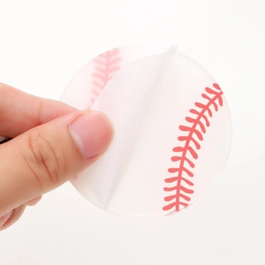 Acrylic baseball keychain blank with red stitching being peeled from protection film