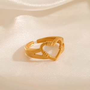 Minimalist gold heart hands ring on silk background in a high-quality product shot