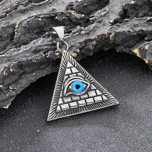 Macro shot of silver Pyramid Evil Eye pendant on dark rustic stone background