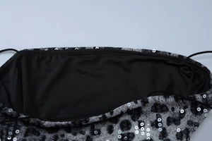 Close-up of leopard print fabric with silver sequins and black spaghetti straps detailing