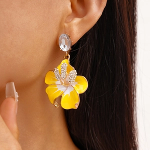 Primo piano di orecchini a fiore vintage con petali smaltati e diamanti brillanti