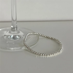Minimalist 925 sterling silver bead bracelet displayed on a glass stem, elegant silver jewelry
