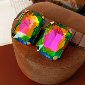Close-up of vintage rectangle earrings with colorful gradient crystals in metal claw settings