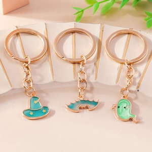 Halloween keychain set with teal enamel bat ghost and wizard hat charms on shell stand