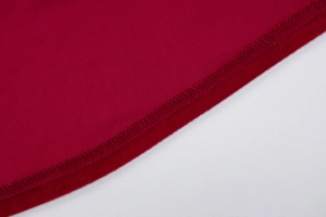 Vue détaillée des coutures en tissu rouge et de la finition de l'ourlet sur la robe