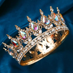 Detailed close-up of golden bridal crown with sparkling teardrop crystals on blue satin