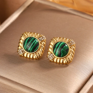 Detail of square gold earrings with malachite stone and rhinestones on jewelry lining