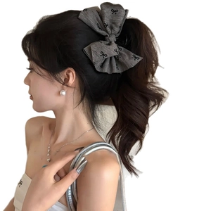 Large grey fabric bow hair claw clip with bow prints on stylish model side view