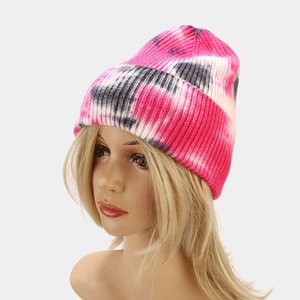 Detail of tie-dye knit beanie in pink and black on a model with white background