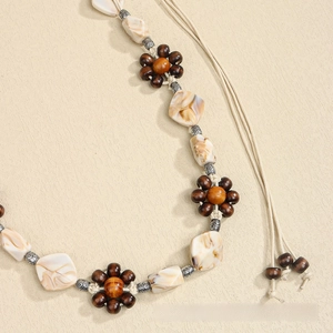 Close-up of bohemian woven cord with wood flower beads and vintage silver accents