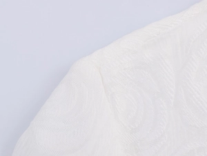 Close-up of white jacquard fabric texture and shoulder stitching on elegant dress