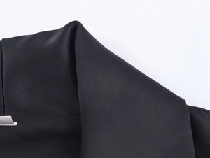 Detailed macro shot of high-quality black satin fabric texture and smooth folded seams