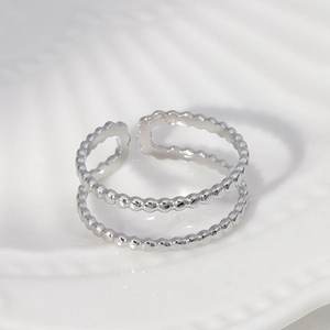 Minimalist silver double-layered open ring with beaded texture on a white surface