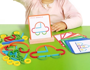 Detail of wooden logic puzzle blocks and difficulty cards for children learning shapes