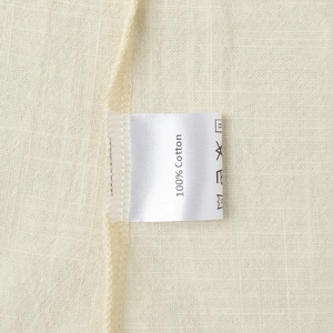Detailed close-up of 100% cotton fabric texture and care label on a sleeveless dress