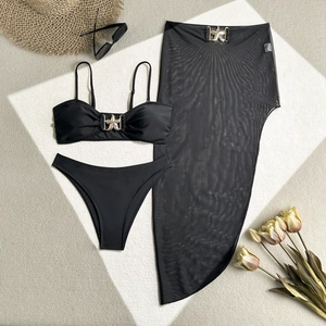 Dettaglio del bikini nero a tre pezzi con fibbie a stella marina dorate e gonna in rete