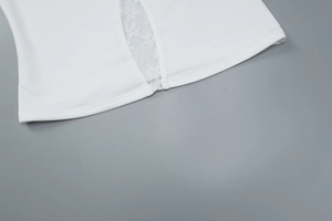 Close-up of white floral lace trim detail and woven fabric texture on the hemline
