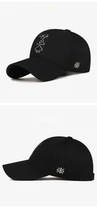 Detail of spade K embroidery and cross lettering on black cotton baseball cap