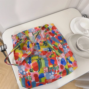 Detail of colorful abstract floral tote bag on white stand with a ceramic cup