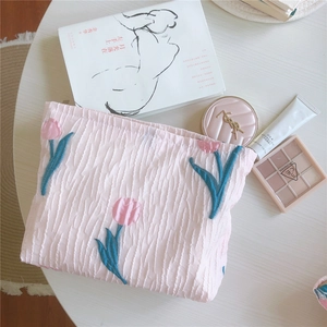 Détail d'une trousse à maquillage en seersucker rose avec broderie tulipe élégante