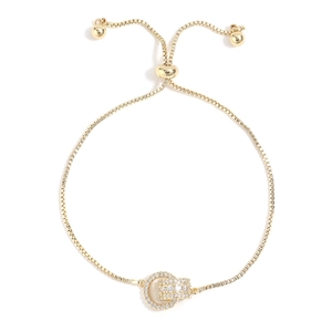 Bracciale a doppio anello regolabile in oro con micro zirconi su sfondo bianco