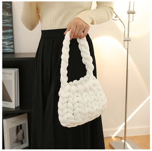 Detail of a white chunky knit handmade tote bag featuring thick yarn and woven texture